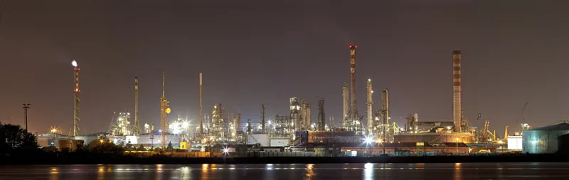Industrial plant lit at night reflected in the water