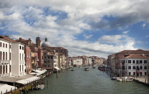 Venetian canal with historic buildings under a cloudy sky