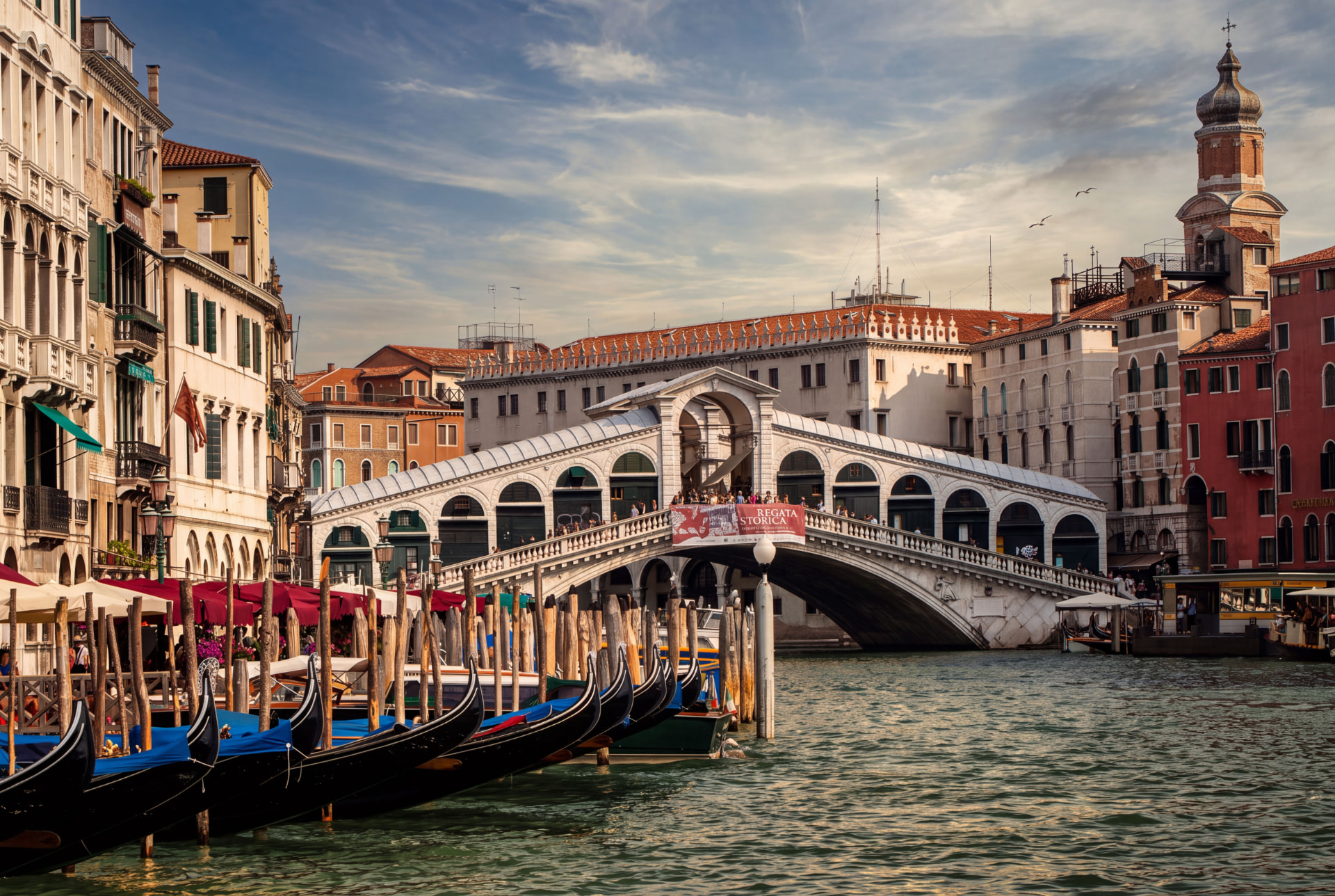 Rialto Bridge over the Grand Canal in Venice with moored gondolas in the foreground