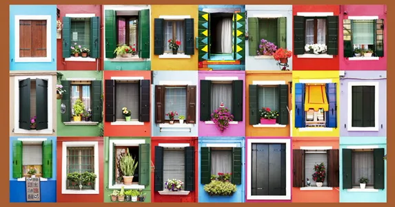 Grid of colourful house windows with shutters and flower pots