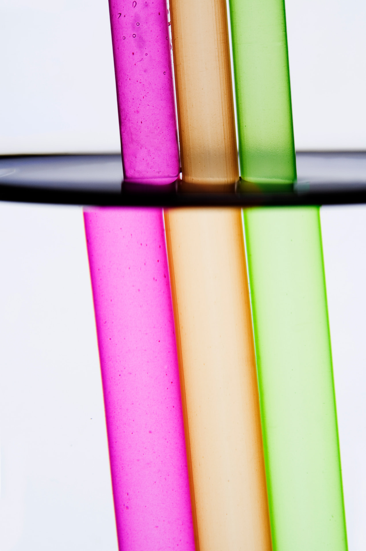 Pink, orange and green translucent tubes against a white background